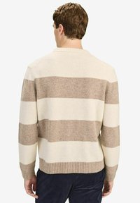 Beige en crèmekleurige gestreepte trui met een geribbelde onderkant. Zachte textuur, ronde halslijn en lange mouwen. Gezellige, relaxte pasvorm.
