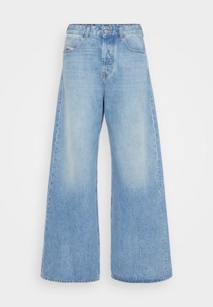 Jeans de perna larga em azul claro, feitos de denim. Apresentam um design clássico de cinco bolsos, fecho com botão e áreas desgastadas para um aspeto vintage.