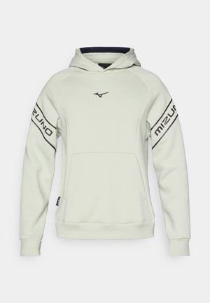 Svetlo šedá mikina s kapucňou a predným vreckom, s čiernym nápisom "Mizuno" na rukávoch. Hladká textúra a ribbované manžety a lem.