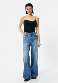 Denim flared jeans in medium blue wash, met een hoge taille, vijf-pocket ontwerp en contrasterende stiksels. Glad textuur met een lichte vervaging.