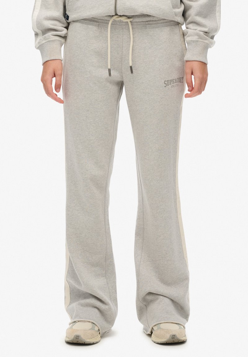 Gray sweatpants made of soft fabric, featuring a drawstring waist, side stripes, and a small logo on the front. Flared leg design.