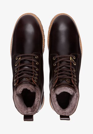 Bottines en cuir marron avec une finition lisse, un col rembourré, des coutures contrastantes en tan et des lacets ronds ; intérieur doublé en fourrure pour plus de chaleur.