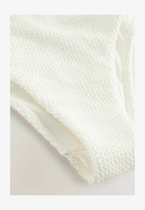 Maillot de bain blanc texturé avec un design en tissu smocké, doublure douce et bords froncés pour plus de détails et de confort.