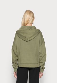 Olivově zelená mikina s kapucí, měkká látka, volný střih, velká kapuce, spadená ramena, žebrované manžety a lem. Jednoduchý, minimalistický design.