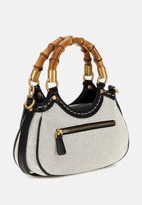 Small curved white fabric handbag with black trim, front zip pocket, and bamboo-style double handles with gold hardware.