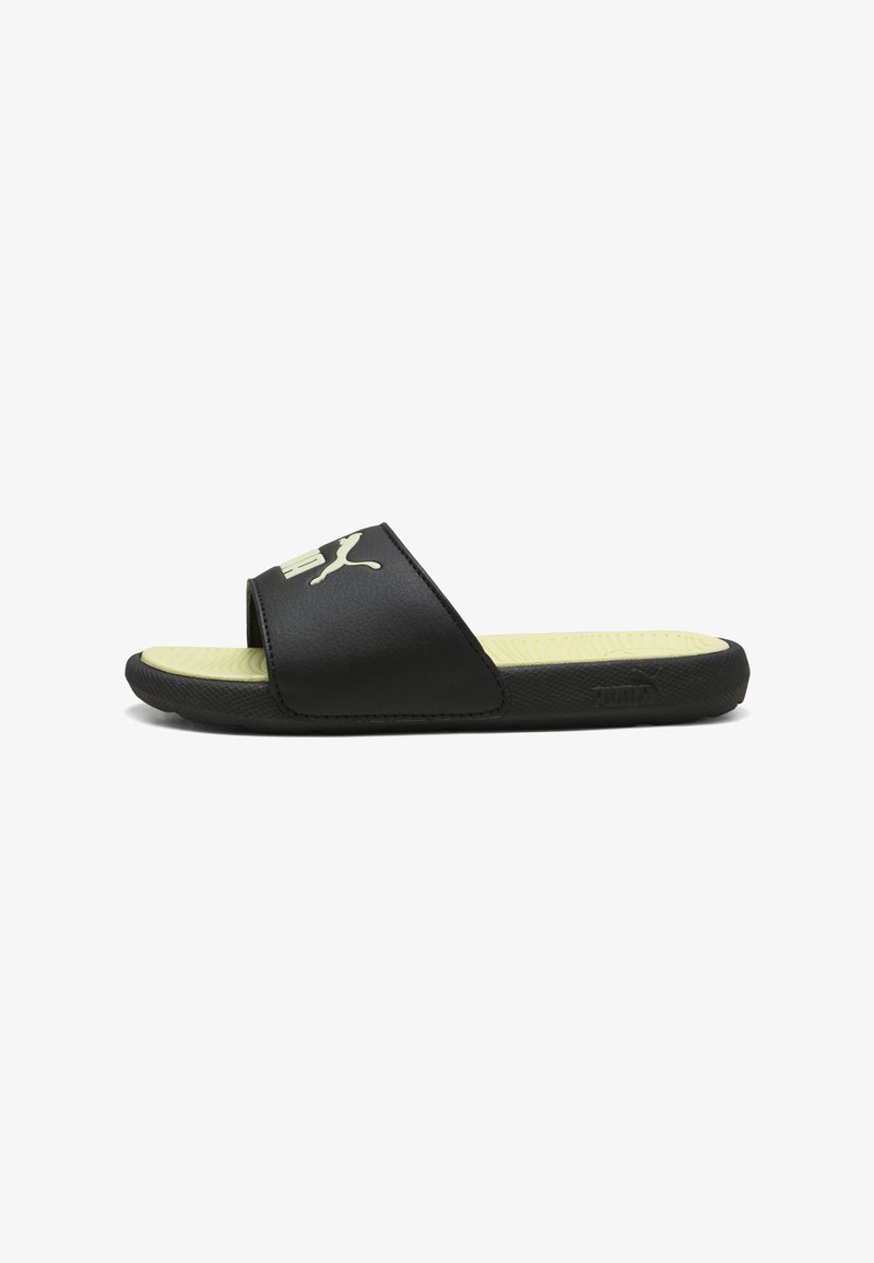 Sandale noire Puma à enfiler avec semelle intérieure jaune texturée et large sangle avec logo Puma blanc, vue de profil sur fond blanc.