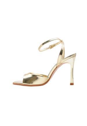 Sandalo metallizzato dorato con tacco alto, cinturino alla caviglia e punta aperta, dotato di un sottile tacco a spillo e chiusura con fibbia.