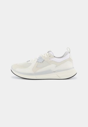 Sneakers with a white and light beige mesh upper, suede accents, and a padded collar. Thick sole with a black rubber tread. Lace-up design.