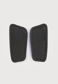 Μαύρα αφρώδη μαξιλαράκια με υφή και σχεδιασμό καπιτονέ, με λείες άκρες, διαμορφωμένα ώστε να εφαρμόζουν άνετα. Κάθε κομμάτι είναι ελαφρώς κυρτό.