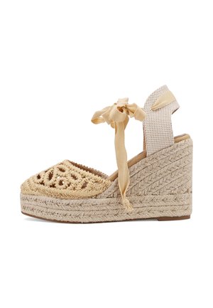 Sandalia cuña tipo esparto beige tejido con amarre en el tobillo, delantero de crochet y tira trasera de tela estampada.