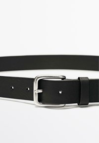 Cintura in pelle nera con fibbia in metallo argentato, caratterizzata da fori uniformemente distanziati per la regolazione e una texture liscia e opaca.