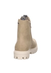 Bottine beige clair avec un extérieur en cuir lisse, semelle blanche épaisse, fermeture éclair latérale et languette avec un logo noir et blanc.