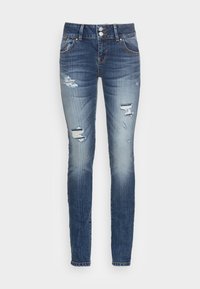 Jeans skinny en denim bleu foncé, avec des détails déchirés et un délavage au niveau des cuisses. Design traditionnel à cinq poches avec fermeture par bouton.