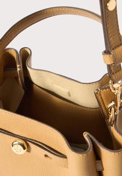 Ταμάν δερμάτινη τσάντα χεριού με υφή, ανοιχτή κορυφή και ασημί μεταλλικά εξαρτήματα. Εσωτερικά επενδυμένη με λεία ύλη.