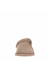 Scarpa slip-on in suede marrone con una fascia incrociata, dettagli cuciti lungo la suola e fondo in gomma texturizzata.