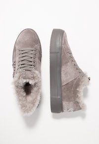 Baskets en daim gris avec doublure en fausse fourrure, lacets, clous décoratifs et semelles épaisses en caoutchouc, vues de dessus et de côté.