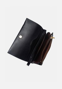 Pochette en cuir noir ouverte montrant l'intérieur marron et une poche zippée dorée avec une fermeture à bouton pression doré sur le rabat.