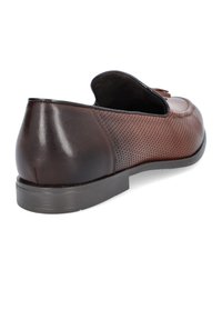 Brązowe skórzane loafery o gładkim wykończeniu, z perforowanymi detalami po bokach i płaską gumową podeszwą. Widok z tyłu ukazuje zaokrąglony obcas.