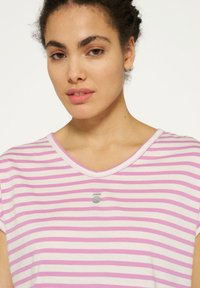 Gestreepte t-shirt met korte mouwen, voorzien van roze en witte strepen, een V-hals en een klein zilveren embleem op de borst. Zachte stoftextuur.