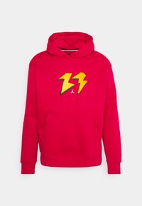 Czerwona bluza z kapturem z dużą żółtą błyskawicą na piersi, wyposażona w przednią kieszeń i ściągacze na rękawach.