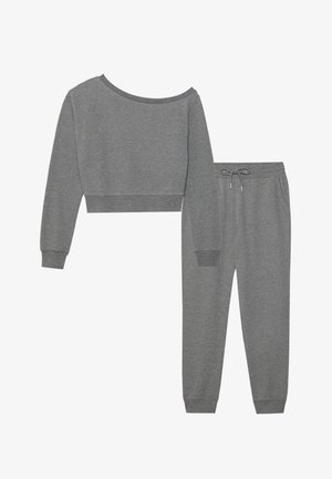 Felpa grigia corta con scollo ampio e maniche lunghe, abbinata a pantaloni della tuta coordinati con cordino e polsini affusolati.