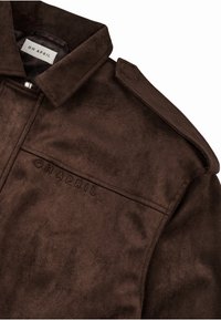 Rudas dirbtinis suedinės švarkas su apykakle, turintis krūtinės kišenę ir išrašytą "OH APRIL" logotipą. Lygus paviršius ir detali siuvimo kokybė.