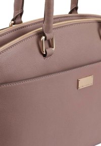 Roze lederen handtas met een gladde textuur, dubbele ritsluiting, accenten in goudkleurige hardware en gestikte details aan de zijkanten.