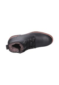 Stivaletto in pelle nera con lacci, punta tonda e morbida fodera in pelliccia. Presenta una suola marrone a contrasto e dettagli di cucitura minimal.