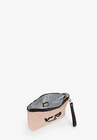 Sacca con zip realizzata in materiale beige intrecciato con bordi neri lucidi. L'interno presenta una fodera argentata, mentre l'esterno mostra un logo.