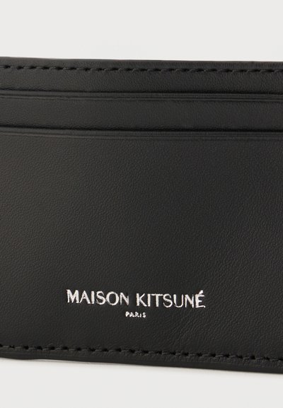 Μαύρη δερμάτινη θήκη καρτών με ραμμένα άκρα και το λογότυπο "MAISON KITSUNÉ PARIS" ανάγλυφο σε ασημί στην κεντρική μπροστινή πλευρά.