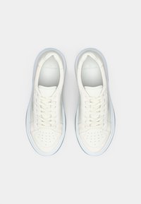 Weiße Leder-Sneaker mit einer glatten Oberfläche, perforierter Zehenpartie und hellgrauen Akzenten. Mit runden Schnürsenkeln und einer strukturierten Sohle.