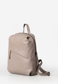 Zaino in pelle grigio chiaro con una texture liscia, forma arrotondata, chiusura con cerniera superiore e tasca frontale con dettagli di cucitura discreti.