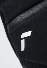 Materiale tessile nero con un accento in pelle texturizzata. Presenta un logo bianco prominente sul lato. La vista ravvicinata mette in evidenza i dettagli delle cuciture.