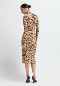 Abito maculato in beige e marrone, con maniche lunghe e silhouette aderente, dotato di collo alto e chiusura con zip sul retro.
