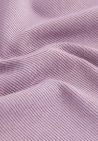 Helle lila gerippte Stoff mit feinen vertikalen Linien, der eine weiche Textur und sanfte Falten zeigt und die Drapierung sowie die Materialqualität betont.
