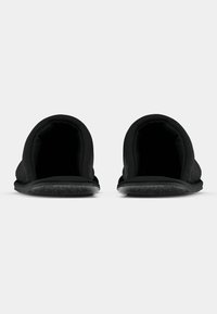 Papuci negri, tip slip-on, cu un material superior moale și talpă din cauciuc texturat. Formă rotunjită a vârfului și fără prinderi vizibile. Design minimalist.