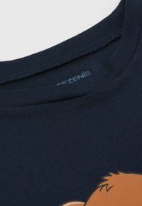 Dunkelblaues T-Shirt mit kurzen Ärmeln und rundem Ausschnitt; mit einem grafischen Druck auf der Vorderseite eines Comic-Charakters in Beige- und Brauntönen.