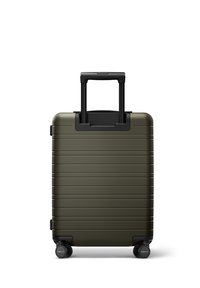 Valise rigide de couleur vert foncé avec des lignes horizontales, une poignée rétractable noire et quatre roues pour une maniabilité facile.