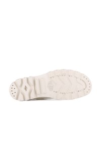 Suela de una zapatilla con una superficie de goma texturizada en color blanco roto, con patrones en zigzag y puntos de agarre circulares para mayor tracción.