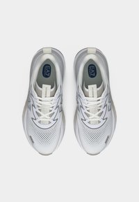 Ζευγάρι λευκών παπουτσιών τρεξίματος EA7 με διαπνεόμενο πλέγμα και κορδόνια στο μπροστινό μέρος, φωτογραφημένα από πάνω σε απλό φόντο.