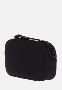 Bolsa rectangular de neopreno negro con abertura con cremallera y asa lateral. Textura suave, diseño minimalista y bordes sin costuras.
