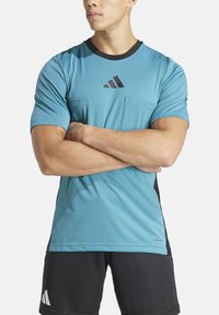 T-shirt atletico blu chiaro con accenti scuri, maniche corte e collo rotondo. Presenta due tasche frontali e un dettaglio del logo nero.