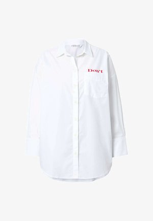White long-sleeve shirt made of cotton, featuring a button-up design, a chest pocket, and red text "Don't" embroidered on the upper left.