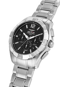 Sølv kronografur med en sort carbon fiber urskive, tre undermeter og lysende viser. Har en urrem og bezel i rustfrit stål.
