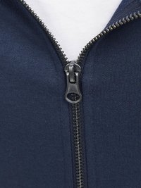 Chaqueta con cremallera de color marino que presenta una textura de tela suave, una cremallera negra con dientes de metal y un forro blanco visible en el cuello.