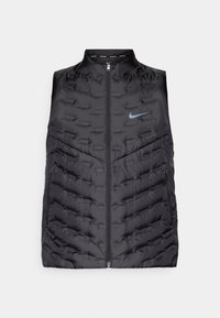 Vest puffer negru cu guler înalt, fermoar frontal și buzunare laterale. Prezintă modele cusute și un logo albastru Nike pe piept.