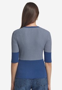 Ribbade stickade tröja med en blandning av ljusgrå och blå nyanser, rund halsringning och korta ärmar. Texturerad tygdetalj.