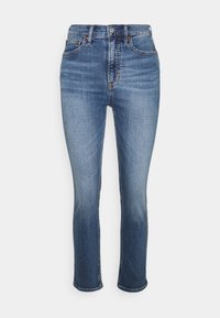 Tmavě modré džíny z denimu s slim fit střihem, středním pasem, designem se pěti kapsami a jemně vybledlým vzorem poblíž stehen a kolen.