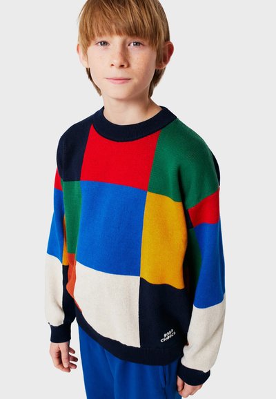 Suéter de punto multicolor con cuadrados llamativos en rojo, azul, verde, amarillo y crema. El diseño tiene un cuello redondo y puños de canalé.
