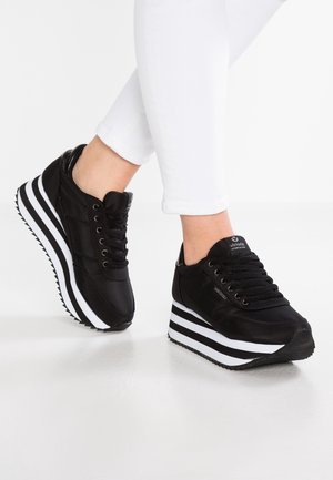 Sneakers platform neri con strisce bianche, realizzati in materiale testurizzato. Presentano un design con lacci e una suola in gomma con battistrada decorato.